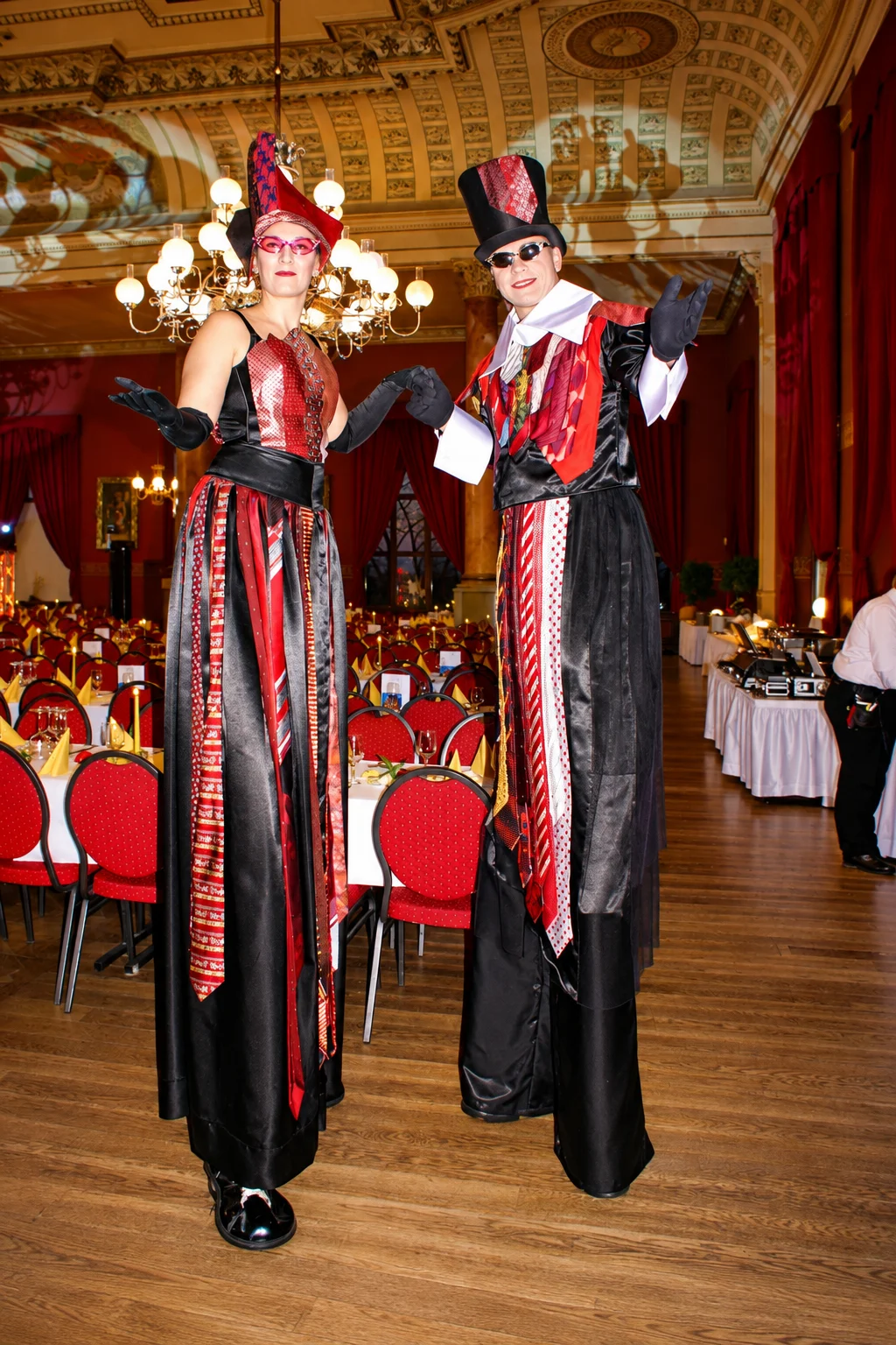Maskierte Stelzenkuenstler im Festsaal