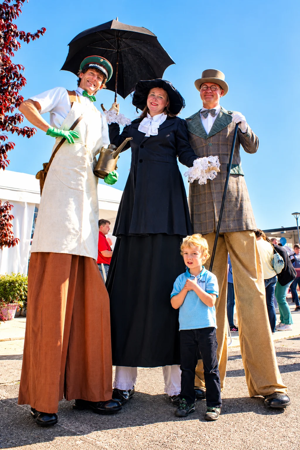Stelzenkuenstler und Kind beim Strassenfest